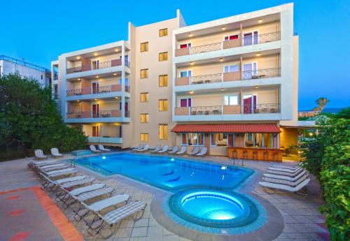 科斯镇帕夫洛斯酒店的公寓大楼设有游泳池和躺椅