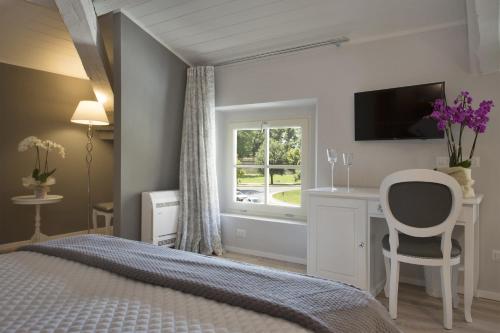 卢卡安娜别墅住宿加早餐酒店的一间卧室配有一张床、一张书桌和一个窗户。
