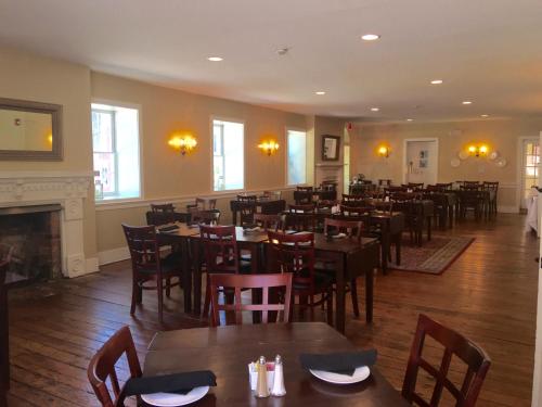RogersvilleHale Springs Inn的一间带桌椅和壁炉的餐厅