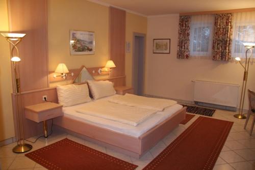 拉茨查赫·奥伯登弗沃尔绰斯酒店的卧室配有一张白色大床和两盏灯。
