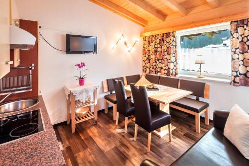 皮茨河谷圣莱昂哈德格莱赛小木屋酒店的厨房以及带桌椅的用餐室。