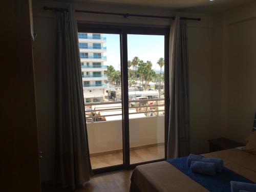拉纳卡Ithaki Phinikoudes Apartment No. 205的一间卧室设有窗户,享有阳台的景色