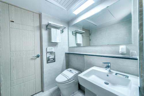 济州市世纪酒店的白色的浴室设有卫生间和水槽。