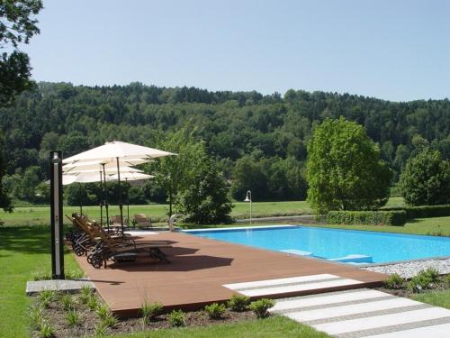 巴特尚道Parkhotel Bad Schandau mit SPA的一个带桌椅和遮阳伞的游泳池