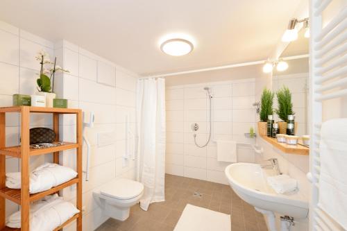 奥伯斯特多夫"Viktoria Ferienhaus" - Annehmlichkeiten von 4-Sterne Familien-und Wellnesshotel Viktoria können mitbenutzt werden的白色的浴室设有卫生间和水槽。