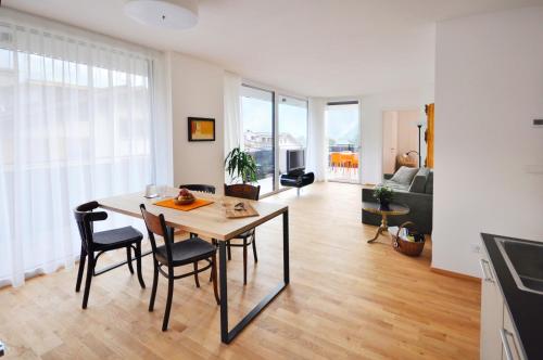 帕尔奇内斯Alpenchalet Apartments的用餐室以及带桌椅的起居室。