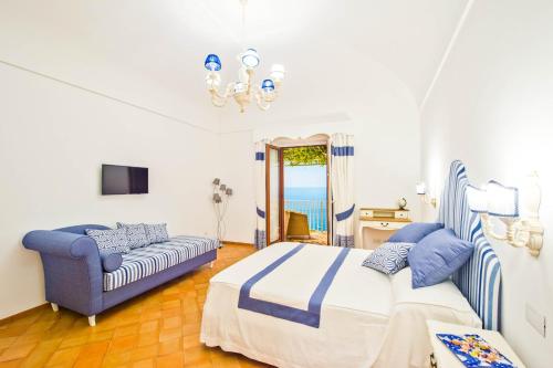 波西塔诺五家公寓酒店的一间卧室配有一张床和一张沙发