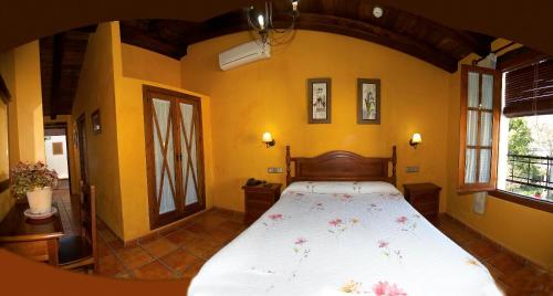 埃尔博斯克恩日克卡尔维洛酒店的卧室配有一张大床,位于拥有黄色墙壁的房间