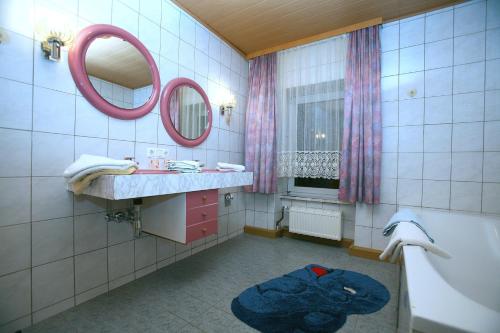毛特豪森玛丽加斯特霍夫酒店的一间带水槽、浴缸和镜子的浴室