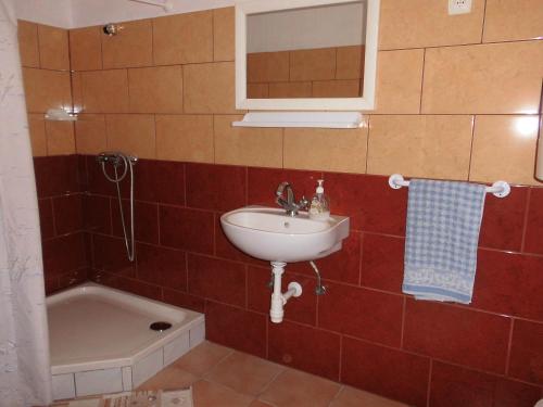 沙罗什保陶克Fenyves Apartman的浴室配有盥洗盆和浴缸。