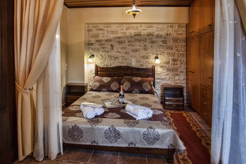 阿瑞罗波利斯Erontas的一间卧室设有一张床和砖墙