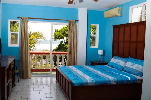 拉利伯塔德萨巴斯海滩度假酒店的一间蓝色卧室,配有一张床和一个阳台