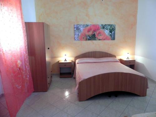 托雷圣乔万尼乌Villetta Sara的一间卧室配有一张床和两个带灯的床头柜