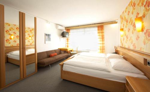 卡尔斯鲁厄艾尔普林森豪夫酒店的一间卧室配有一张大床和一张沙发