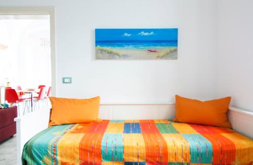 奥斯图尼Micca House的一间卧室配有一张带彩色毯子的床