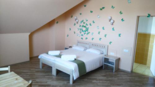 陶格夫匹尔斯阿森纳尔旅馆的卧室配有一张带绿色蝴蝶的床铺,墙上挂着绿蝴蝶