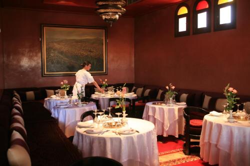 马拉喀什阿尔法希亚阿古达尔酒店的坐在餐桌旁的女人