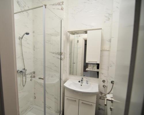 洛夫兰Hotel Villa Laurel的白色的浴室设有水槽和淋浴。