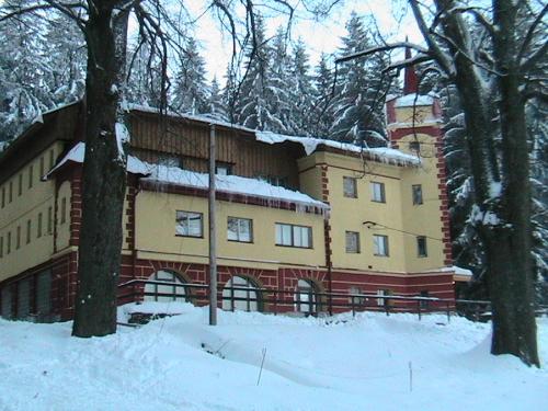 霍捷索瓦斯特拉Turistická ubytovna Zámeček的一座大雪楼,有树