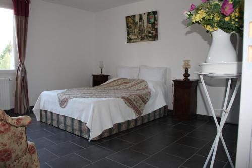 丰维耶Villa des Oliviers的一间卧室,配有一张床和花瓶
