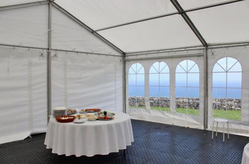 诺德什蒂Aldeia do Priolo的白色帐篷,配有餐桌和食物