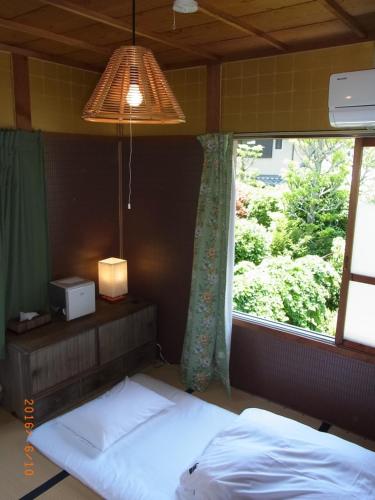 京都禅林寺三休荘町家度假屋的一间卧室设有两张床和窗户。