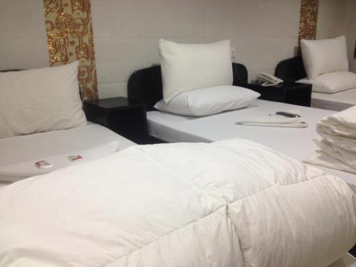 香港曼哈顿旅馆的配有2张床的带白色床单和枕头的客房