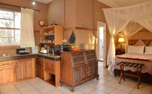 ChobeMuchenje Self Catering Cottages的一个带水槽的厨房和一张位于客房内的床