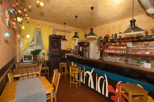 博希尼荚沃咖菈莫旅馆的餐厅设有酒吧,配有木桌和椅子