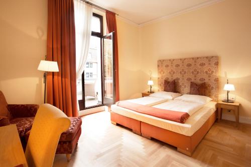 美因河畔法兰克福佛罗伦萨别墅酒店的一间卧室设有一张床和一个大窗户