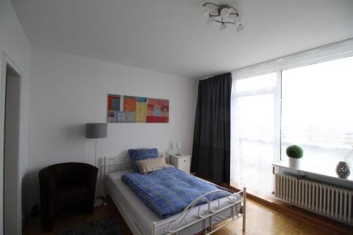 圣奥古斯丁Apartments Sankt Augustin的卧室配有床、椅子和窗户。