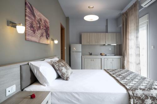 艾斯普罗瓦塔Troia Resort Luxury Studios的一间带白色床的卧室和一间厨房