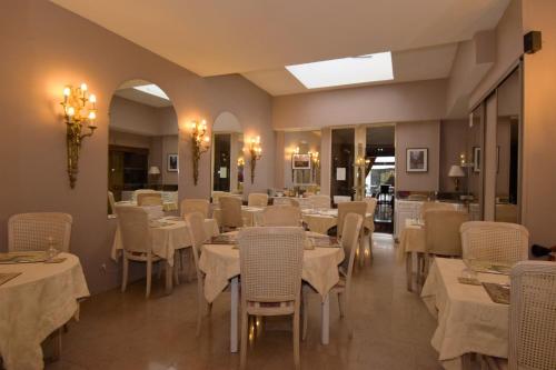 鲁昂鲁昂中心丹迪酒店的一间设有白色桌椅的用餐室