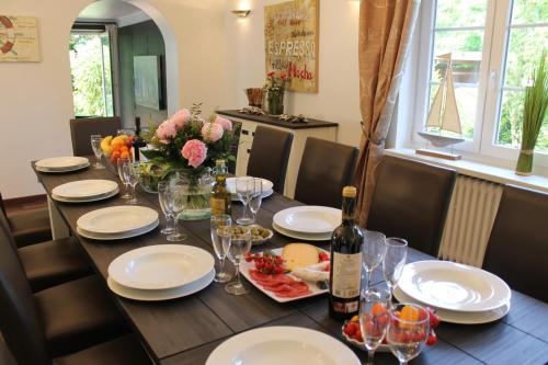 韦斯特兰Ferienhaus Nadja的餐桌,配有一瓶葡萄酒和玻璃杯