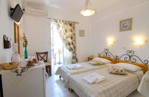 阿莫尔戈斯Pension Ilias - Chora Amorgos的一间卧室配有两张床和一张带毛巾的桌子。