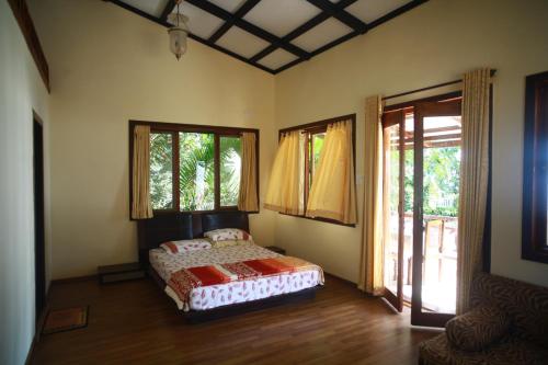 穆鲁德SaffronStays Little Paradise, Murud的一间设有床铺的卧室,位于带窗户的房间内