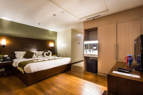马尼拉Armada Hotel Manila的酒店客房,配有床和电视