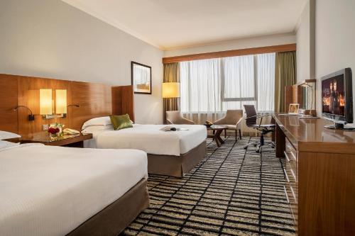 迪拜迪拜朱美拉罗塔纳酒店的酒店客房配有两张床和一张书桌