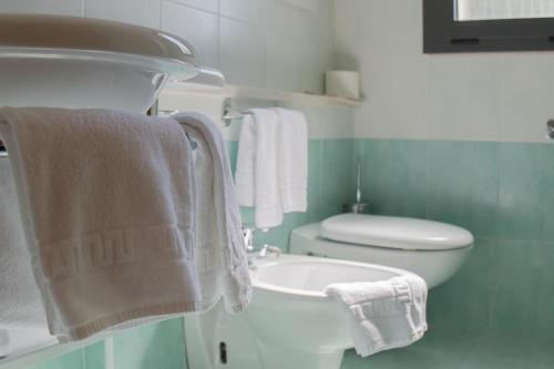 利尼亚诺萨比亚多罗埃尔维亚酒店的浴室配有卫生间、水槽和毛巾。