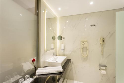 法里拉基卡吕普索宫度假村的白色的浴室设有水槽和镜子