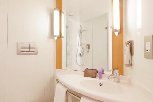 卡莱尔卡莱尔宜必思城市中心酒店的白色的浴室设有水槽和淋浴。
