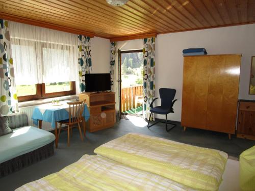 格绍萨姆斯宾馆的一间卧室配有两张床、一张桌子和一台电视。