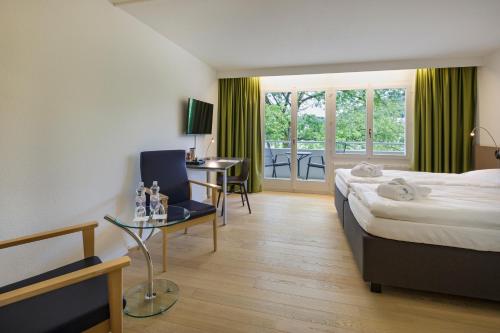 巴德楚尔察赫VitalBoutique Hotel Zurzacherhof的配有一张床、一张书桌和一扇窗户的酒店客房