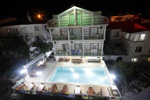 达特恰Huzur Royal Hotel的一座大型建筑,前面设有一个游泳池