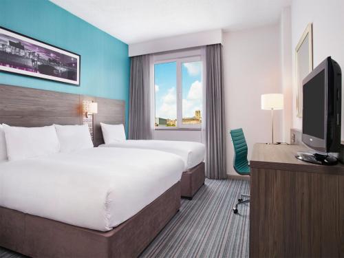 诺丁汉Leonardo Hotel Nottingham的酒店客房设有一张大床和一台电视。
