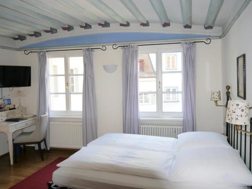 拉芬斯堡奥伯托酒店的卧室配有一张床、一张书桌和窗户。