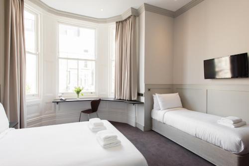 伦敦莫布雷科尔特酒店的一间酒店客房,设有两张床和电视