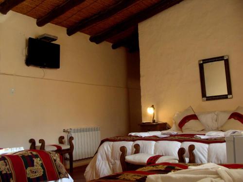 蒂尔卡拉图配斯特酒店的一间卧室设有两张床,墙上配有电视。