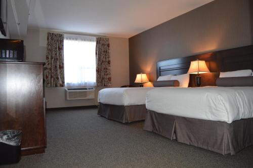 Maple CreekCobble Creek Lodge的酒店客房设有两张床和窗户。