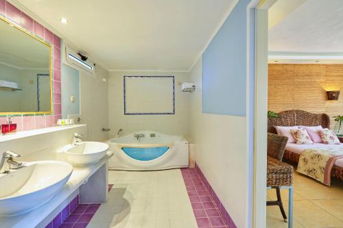 普里诺斯太阳海酒店的浴室配有两个盥洗盆和浴缸。